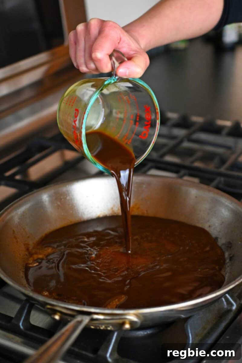 Wholesome Enoki Beef Wraps 16 Pouring All-Purpose Stir-Fry sauce into a large stainless steel skillet after the beef has been removed.