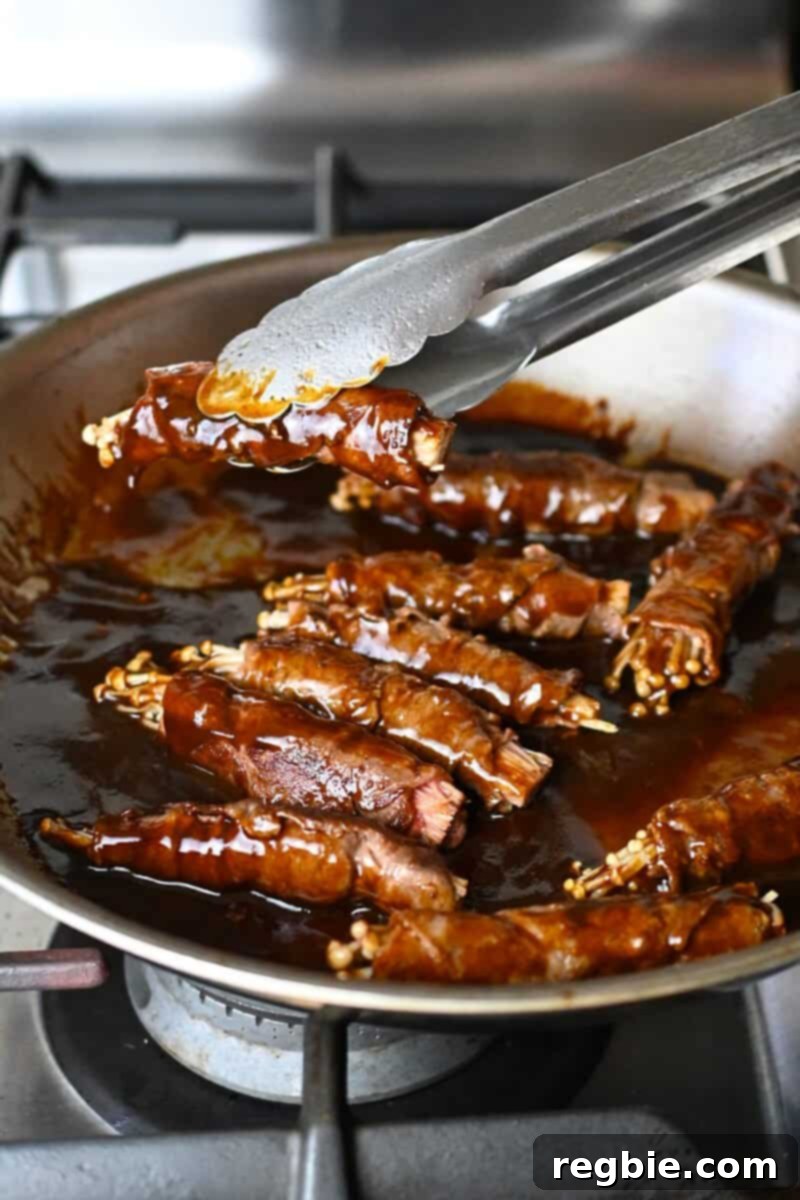 Wholesome Enoki Beef Wraps 18 Adding beef and enoki rolls to a skillet filled with a thickened brown sauce, ensuring even coating.