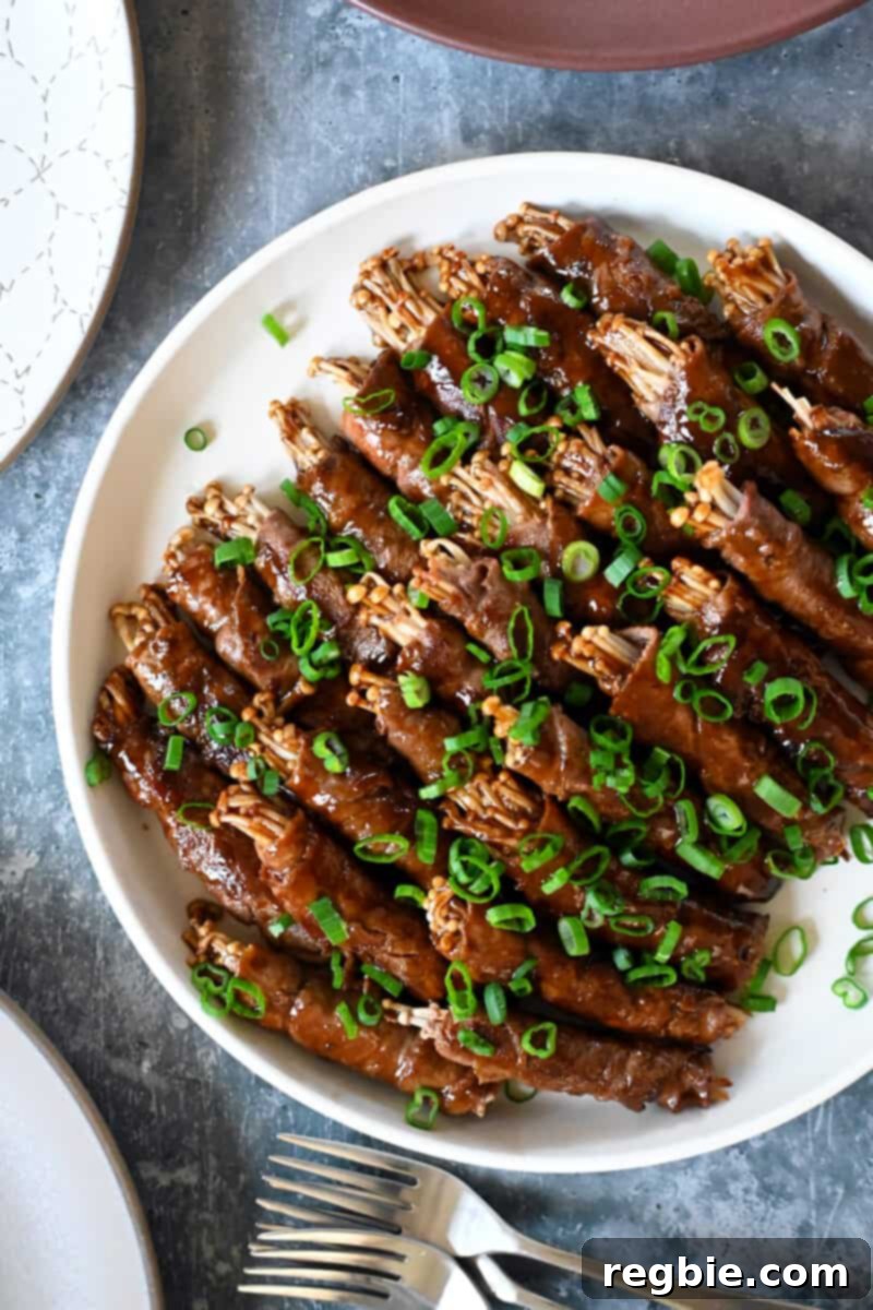 Wholesome Enoki Beef Wraps 20 An overhead shot of paleo, Whole30, and keto beef and enoki mushroom rolls with sliced green onions on top, ready to serve.