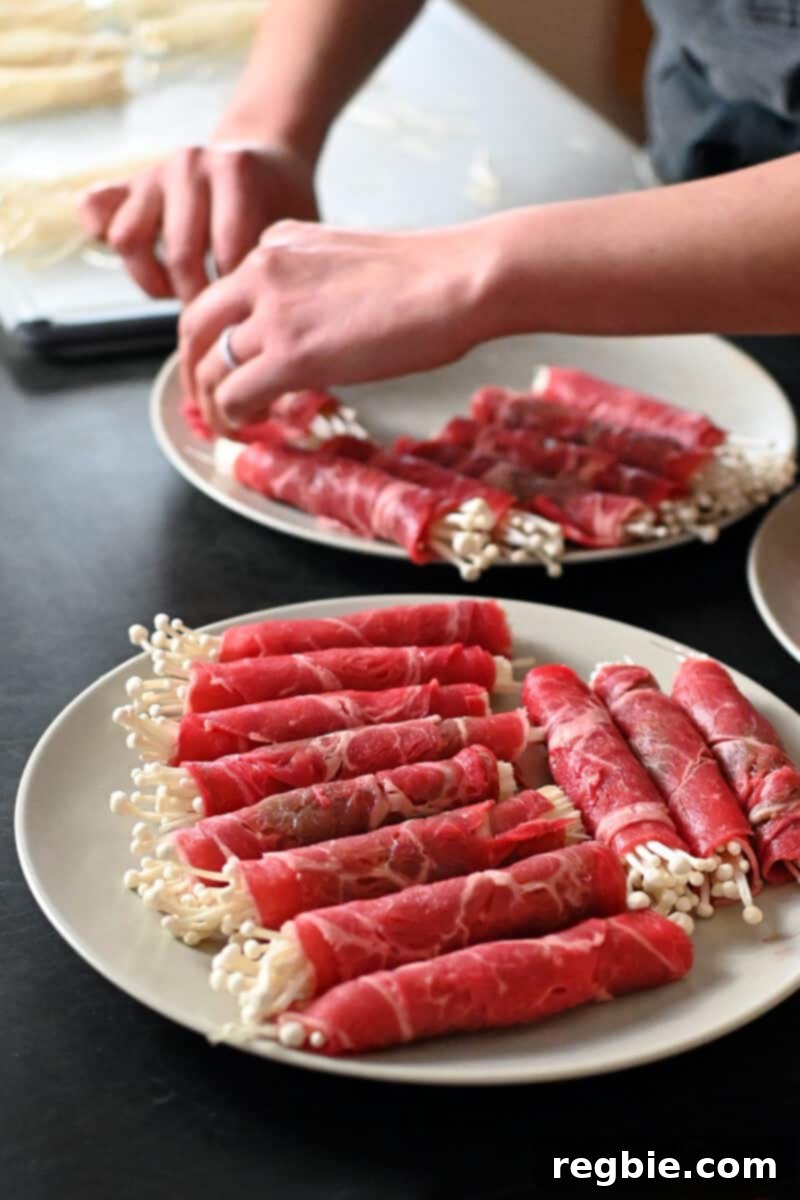 Wholesome Enoki Beef Wraps 9 Two plates filled with neatly arranged beef and enoki mushroom rolls ready to be cooked.