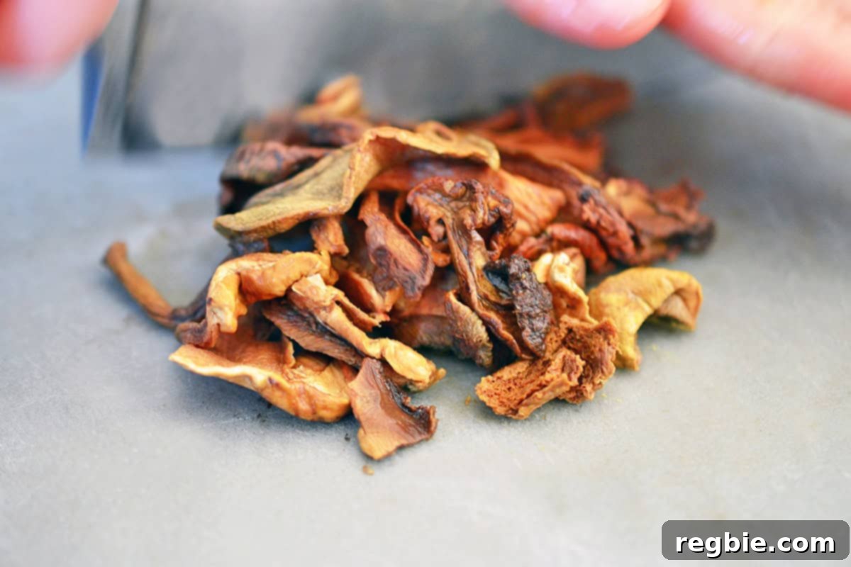 Rehydrated dried porcini mushrooms on a gray cutting board.