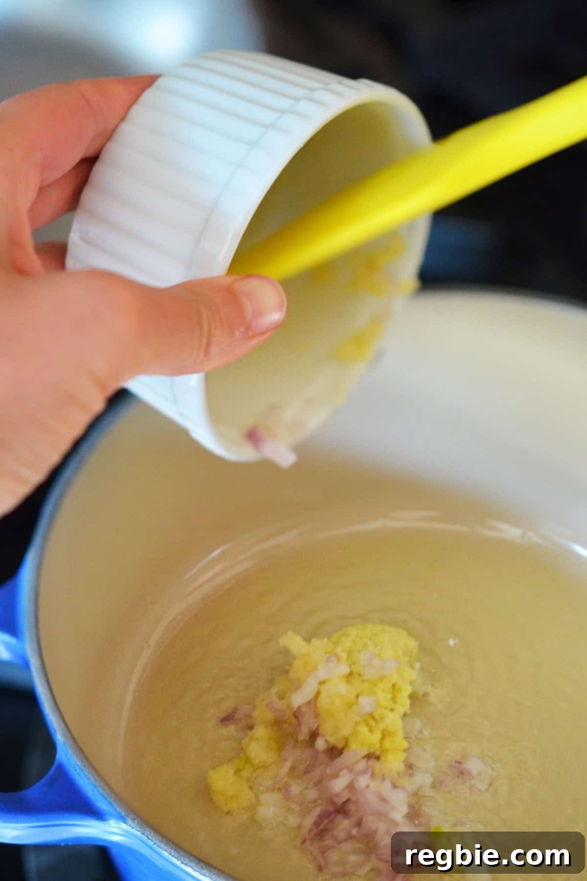 Sautéing finely minced shallot, garlic, and ginger in some fat in a small saucepan, filling the kitchen with fragrant aromas.