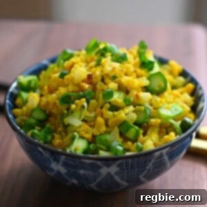 A bowl filled with golden cauliflower fried rice, beautifully plated and ready to serve.