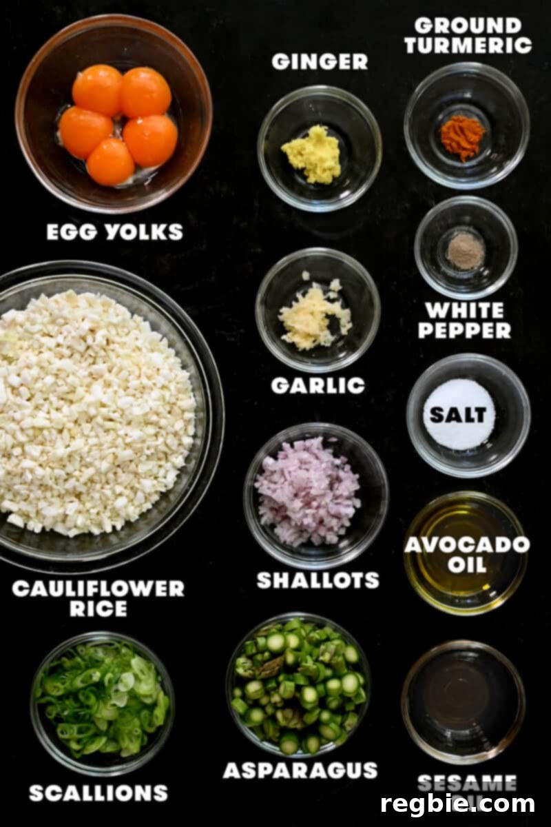 An overhead shot of the raw ingredients for golden cauliflower fried rice, neatly arranged on a cutting board.