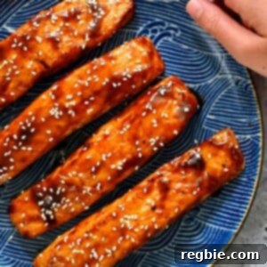A blue plate with four air fryer salmon filets with honey sriracha glaze.