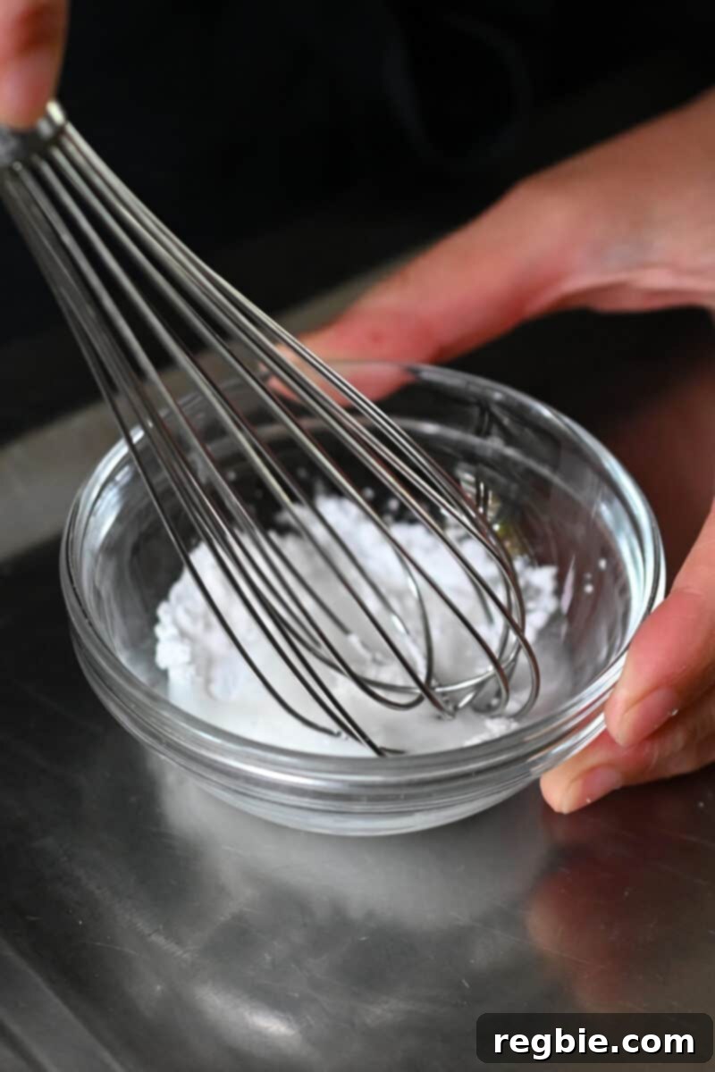 A close-up shows arrowroot powder being vigorously whisked with water in a small bowl, forming a smooth slurry.