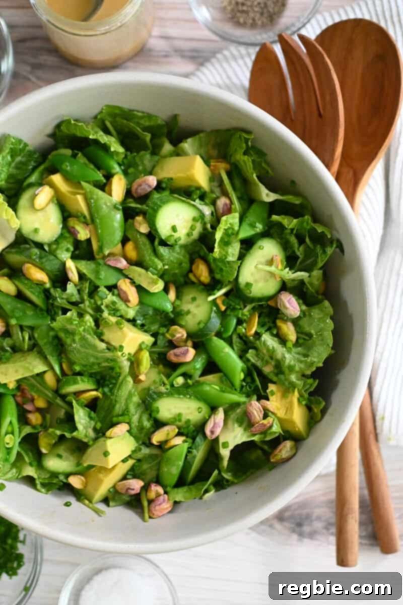 Whole30 Vegan Asian Chopped Salad 2 An overhead shot of a big white bowl filled with a vegan and Whole30 chopped salad with sesame ginger dressing, showcasing fresh vegetables and vibrant colors.