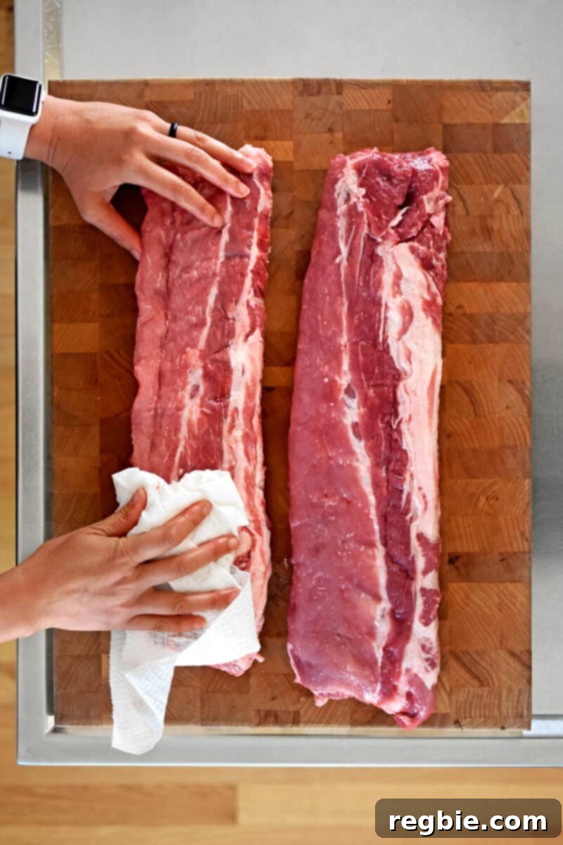 An overhead shot of two raw racks of baby back ribs.