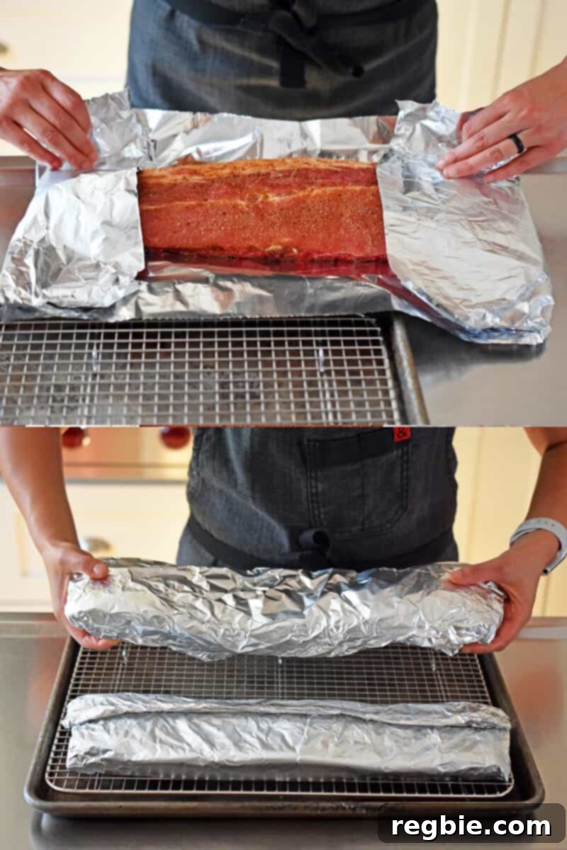 Wrapping the baby back ribs rack in foil and placing it on a wire rack in a rimmed baking sheet.