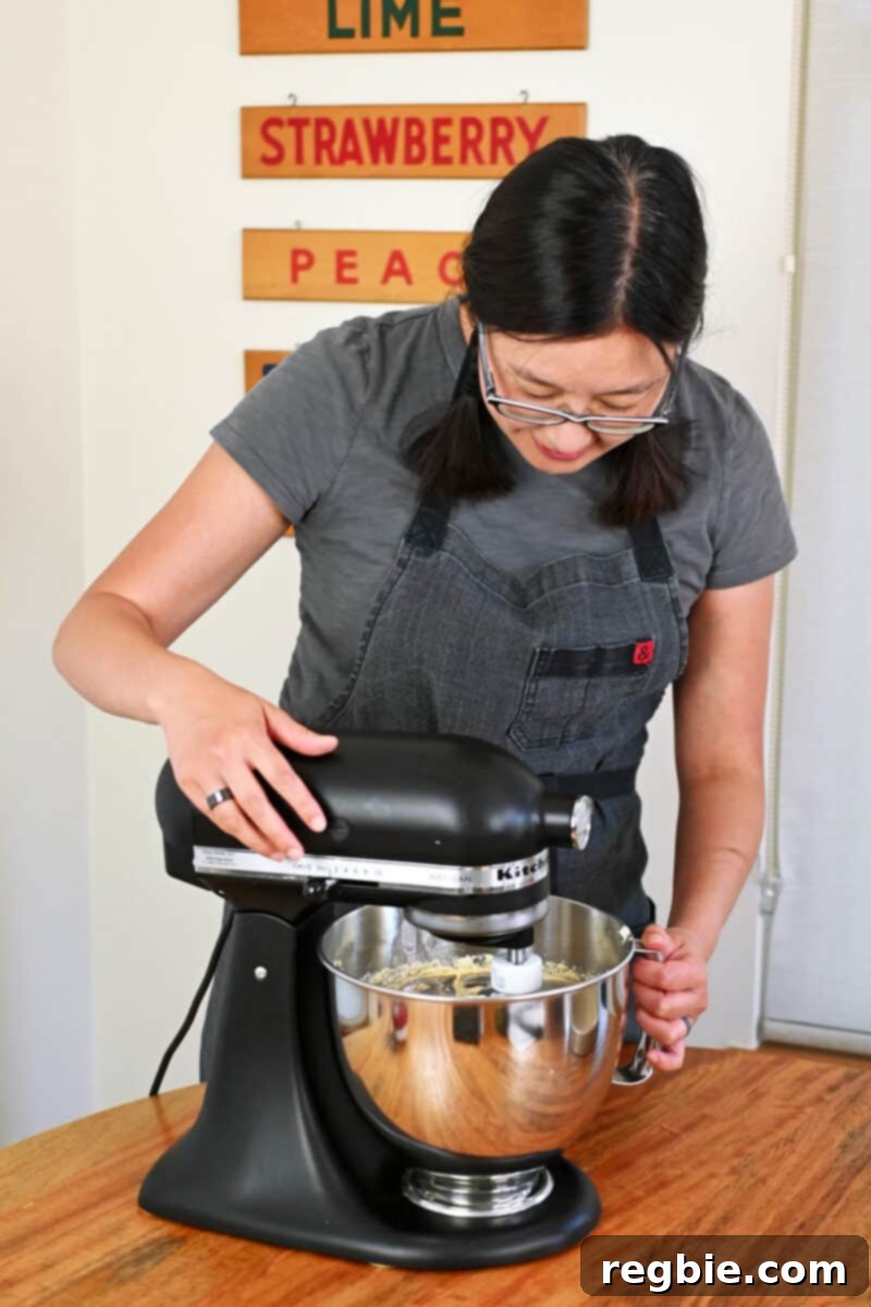 Peach Cloud Cake Paleo Gluten Free 14 An Asian woman is making paleo peach cake batter in a black Kitchen mixer.