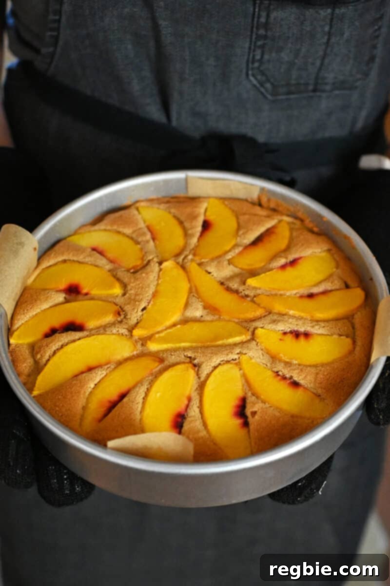 Peach Cloud Cake Paleo Gluten Free 18 Removing a paleo and gluten free peach cake out of an oven.