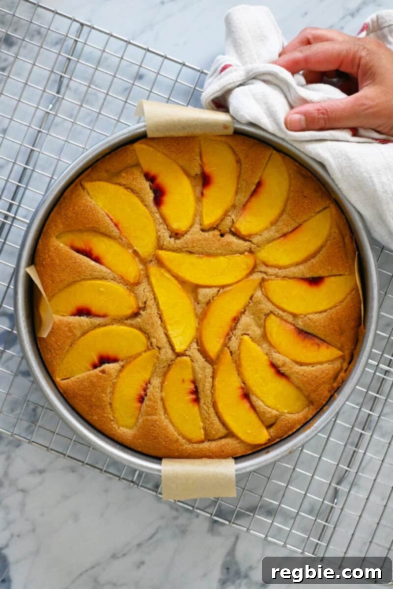 Peach Cloud Cake Paleo Gluten Free 19 A golden brown freshly baked peach cake is cooling on a wire rack.
