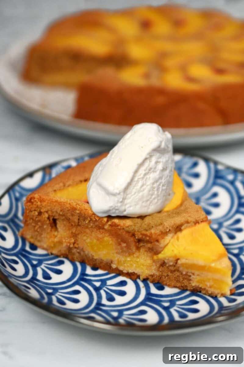 Peach Cloud Cake Paleo Gluten Free 20 A slice of paleo peach cake on a blue plate with a dollop of whipped coconut cream on top.