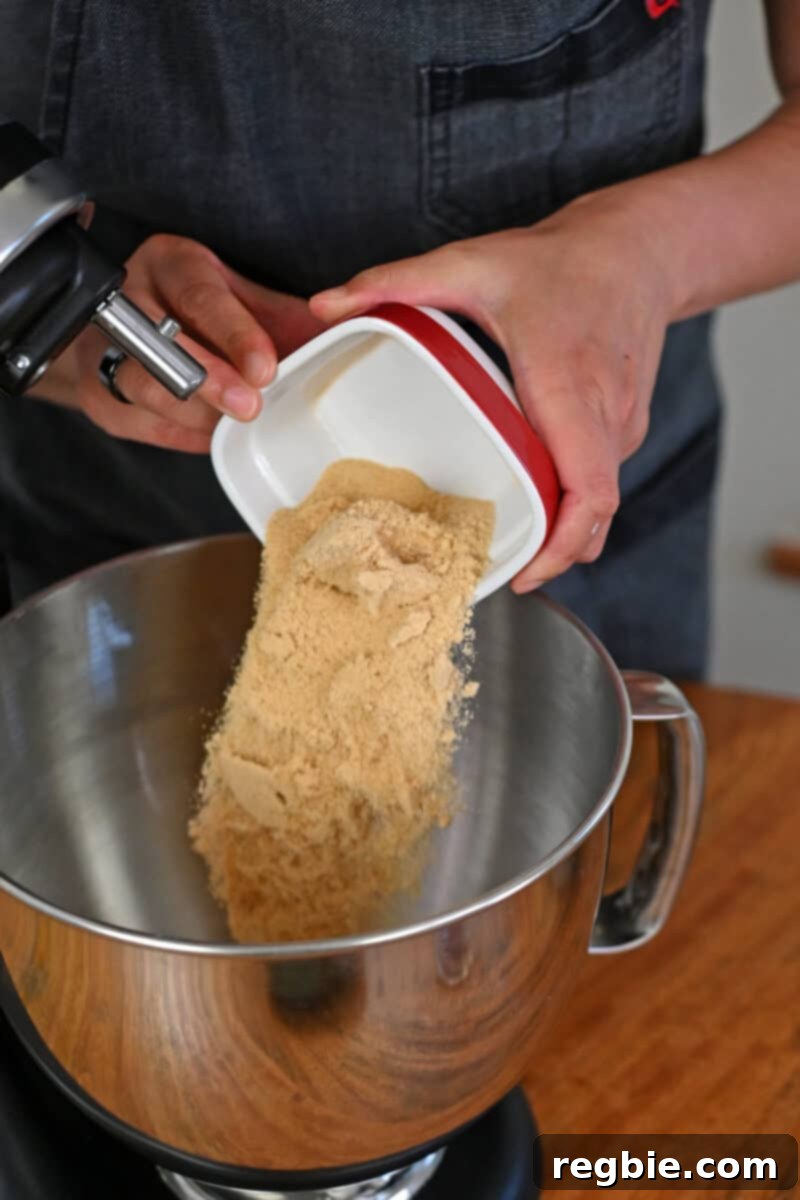 Peach Cloud Cake Paleo Gluten Free 9 Pouring maple sugar into a mixing bowl filled with softened ghee.