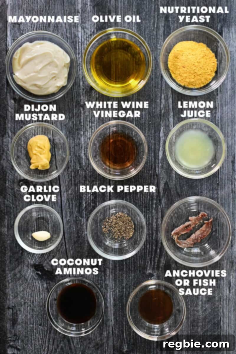 Creamy Dairy Free Caesar Dressing Whole30 Keto 4 A beautifully arranged flat lay of raw ingredients required for making dairy-free Caesar dressing, including jars of mayonnaise, oils, and various condiments.