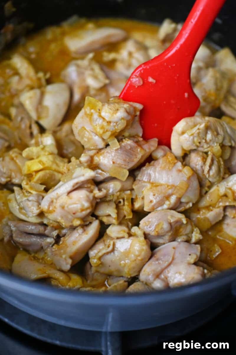 Healthy Instant Pot Chicken Saag Whole30 Keto 13 A closeup photo of cut-up cooked chicken thighs and spices in a pot.