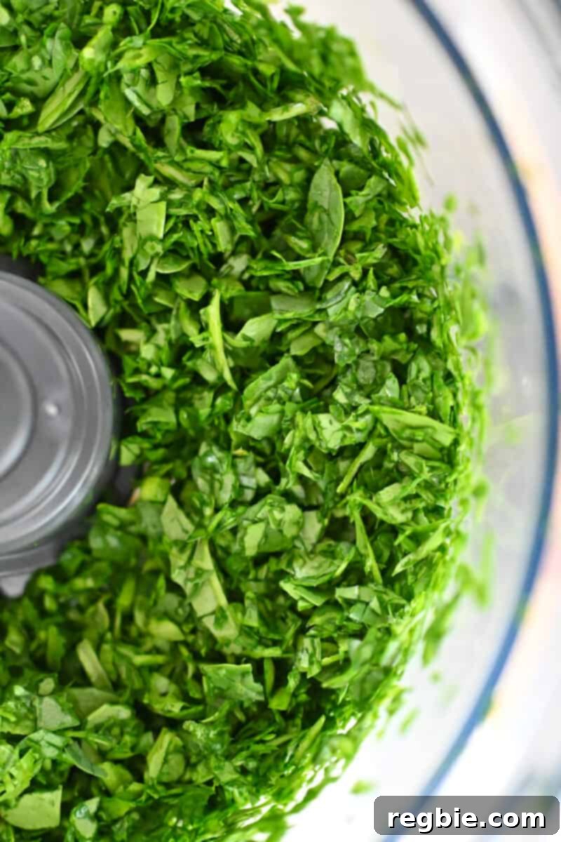 Healthy Instant Pot Chicken Saag Whole30 Keto 4 An overhead shot of chopped spinach in a food processor.