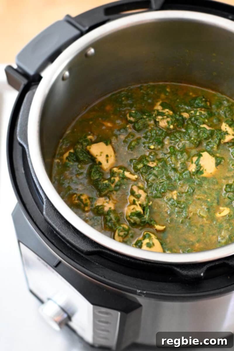 Healthy Instant Pot Chicken Saag Whole30 Keto 5 An open Instant Pot filled with a green chicken curry, Chicken Saag.