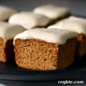 A side view of a paleo and gluten free pumpkin bar topped with a dairy-free cream cheese frosting.