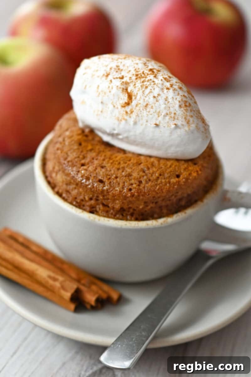 A side shot of a gluten-free cinnamon apple mug cake, fluffy and golden brown, ready to be enjoyed.
