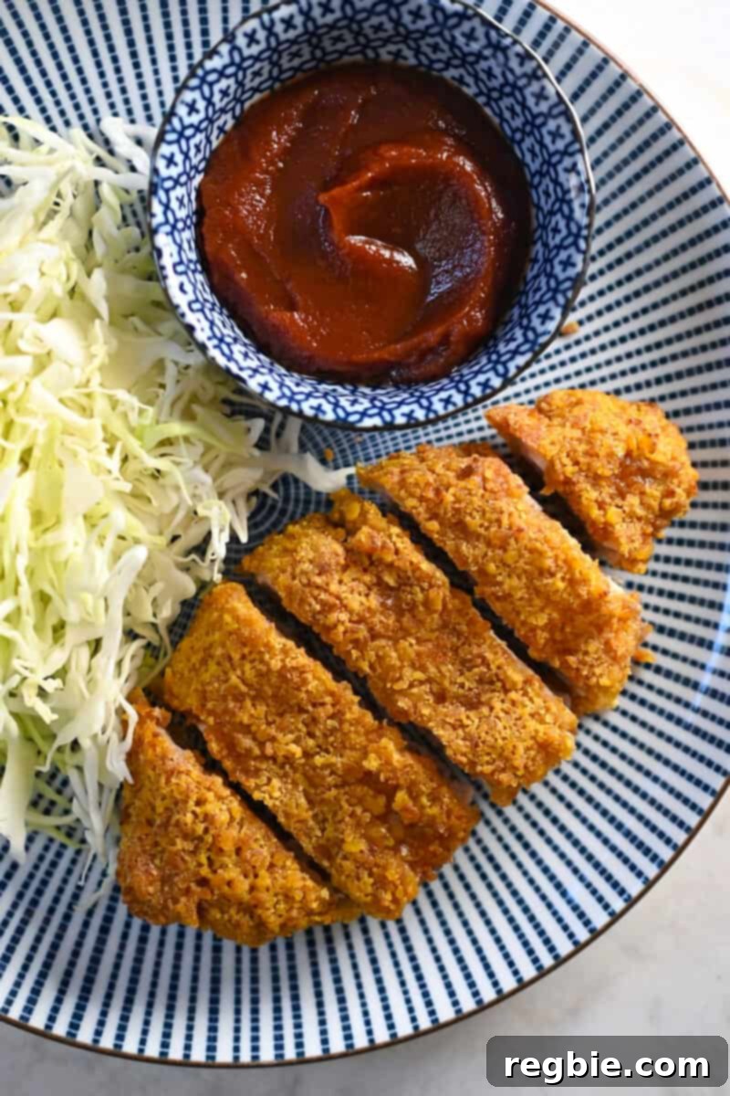 Healthy & Delicious Tonkatsu Sauce (Paleo, Whole30, Vegan) 12 An overhead shot of a plate with paleo tonkatsu next to a pile of shredded cabbage and a small dish of homemade Tonkatsu Sauce, ready to be served.