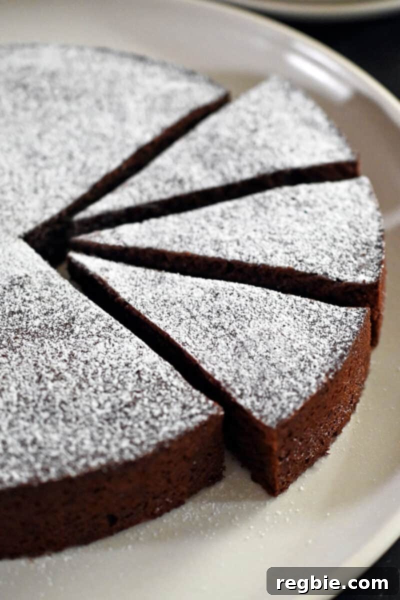 Caprese Chocolate Almond Torte 2 A close up shot of a Torta Caprese, a classic Italian almond flour chocolate cake with three slices cut into it.