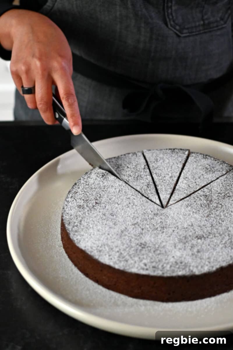 Caprese Chocolate Almond Torte 20 Slicing a Torta Caprese right before serving.