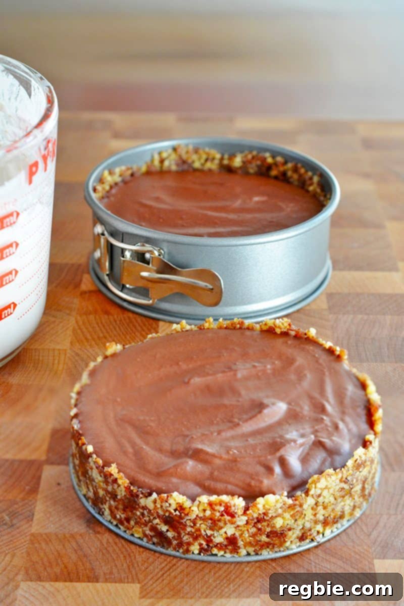 Paleo Vegan Gluten Free Chocolate Graham Cracker Pie 15 Two paleo chocolate pies in springform pans, perfectly formed and ready to be placed in the refrigerator for chilling, ensuring they set beautifully.