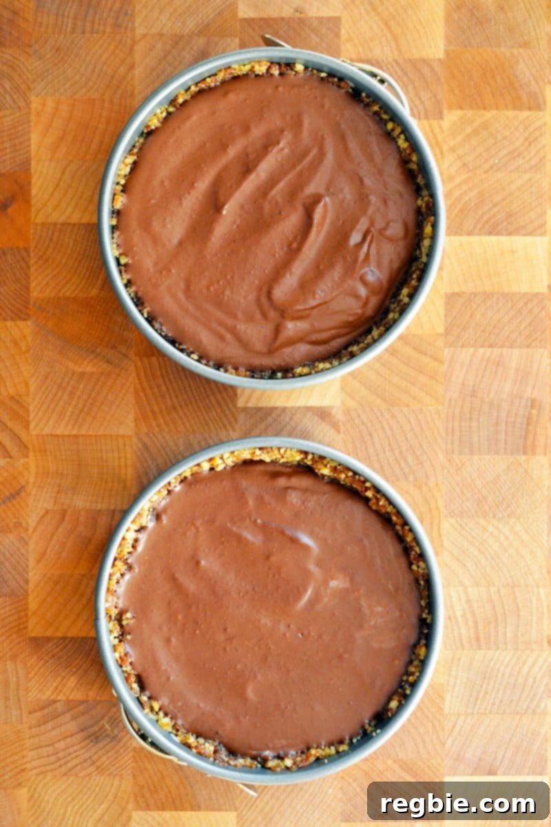 Paleo Vegan Gluten Free Chocolate Graham Cracker Pie 7 An appealing overhead shot of two mini paleo chocolate pies, nestled in springform pans on a rustic wooden cutting board, showcasing their perfect round shapes and rich surfaces.