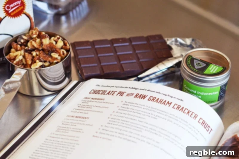 Paleo Vegan Gluten Free Chocolate Graham Cracker Pie 8 The raw ingredients for a paleo chocolate pie, including walnuts, Medjool dates, dark chocolate, and coconut cream, arranged neatly beside an open cookbook.