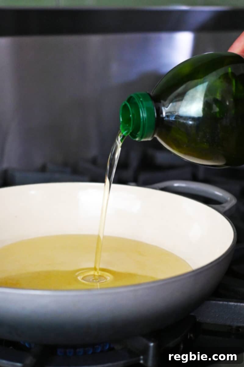 Wholesome Paleo Shrimp Toast 12 Avocado oil being carefully poured into a hot enamel cast iron skillet.