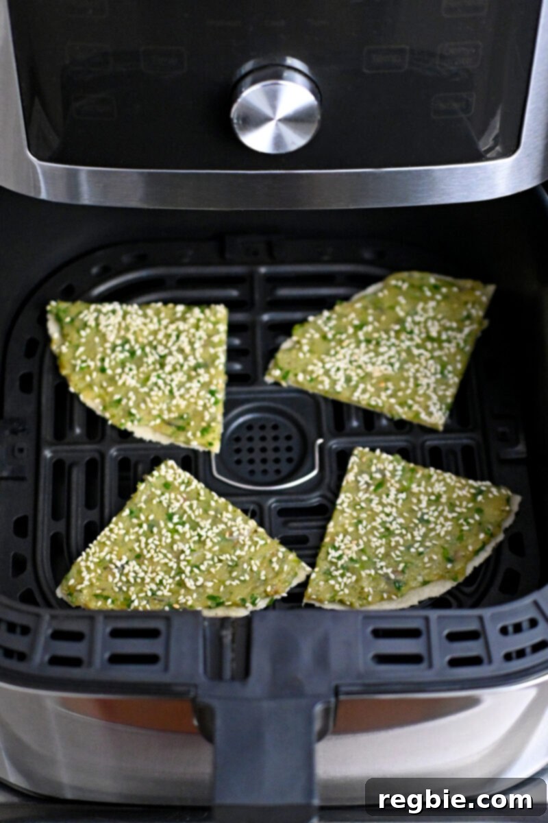 Wholesome Paleo Shrimp Toast 17 Four wedges of raw paleo shrimp toast carefully placed shrimp-side up in an open air fryer basket, ready for cooking.