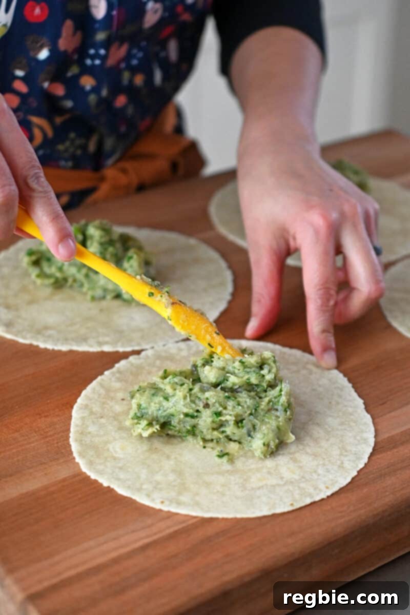 Wholesome Paleo Shrimp Toast 8 A spatula is spreading one-fourth of the uncooked shrimp paste evenly over a grain-free tortilla.