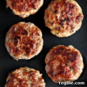 Golden brown homemade Italian sausage patties on a black plate.