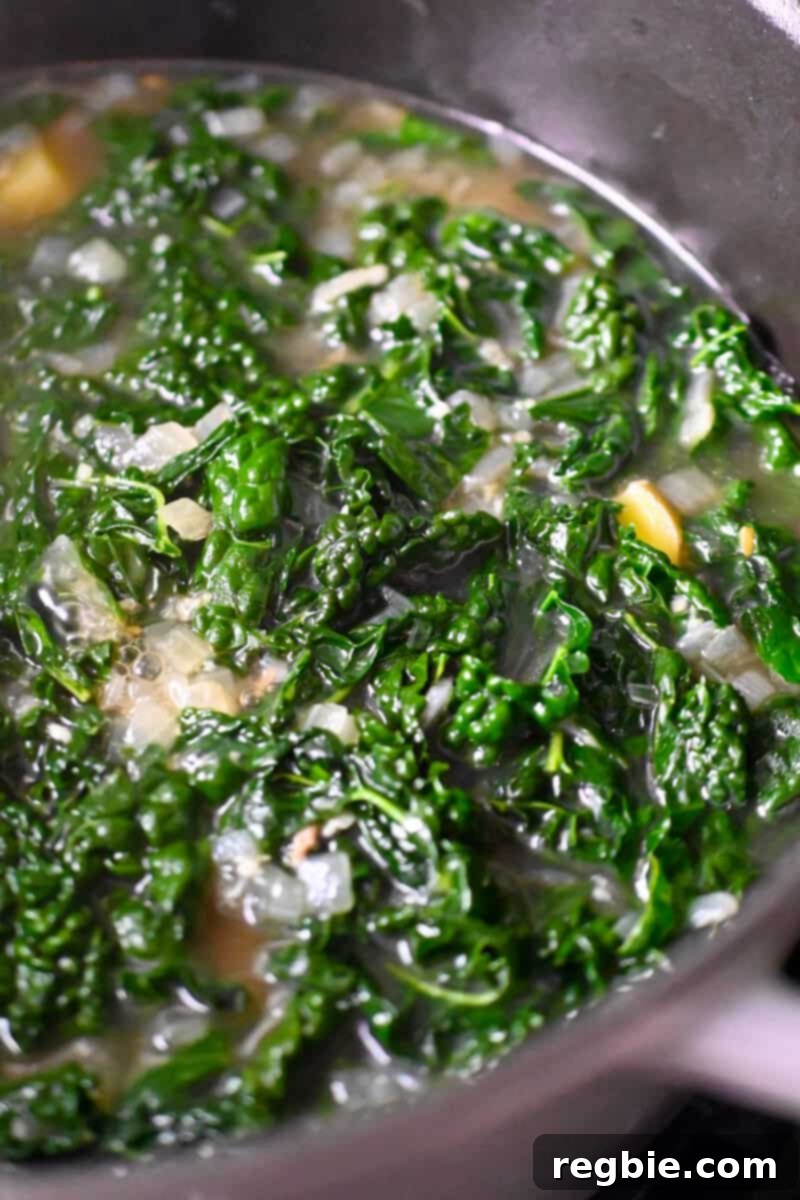 An overhead shot of a simmering pot of Zuppa Toscana before the sausage and cashew cream are added.