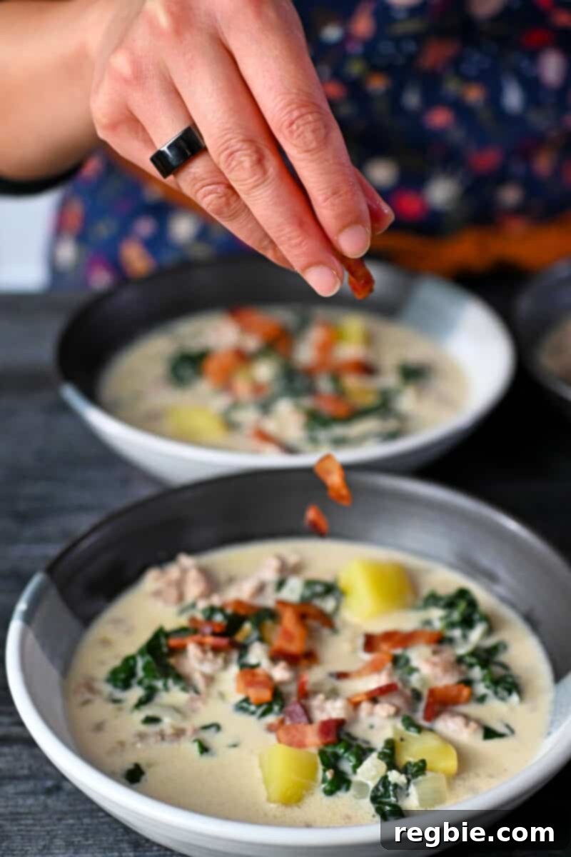 Adding crispy bacon bits to the top of bowls filled with Whole30 Zuppa Toscana.