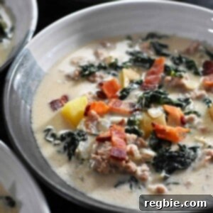 A closeup of a bowl of Whole30 Zuppa Toscana soup topped with crispy bacon bits.