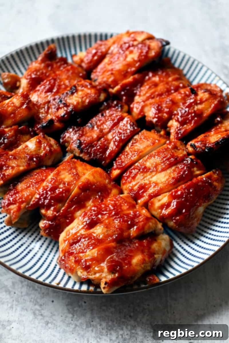 A plate of Char Siu chicken that is sliced up and ready to serve, highlighting its glossy, caramelized sauce and tender texture.