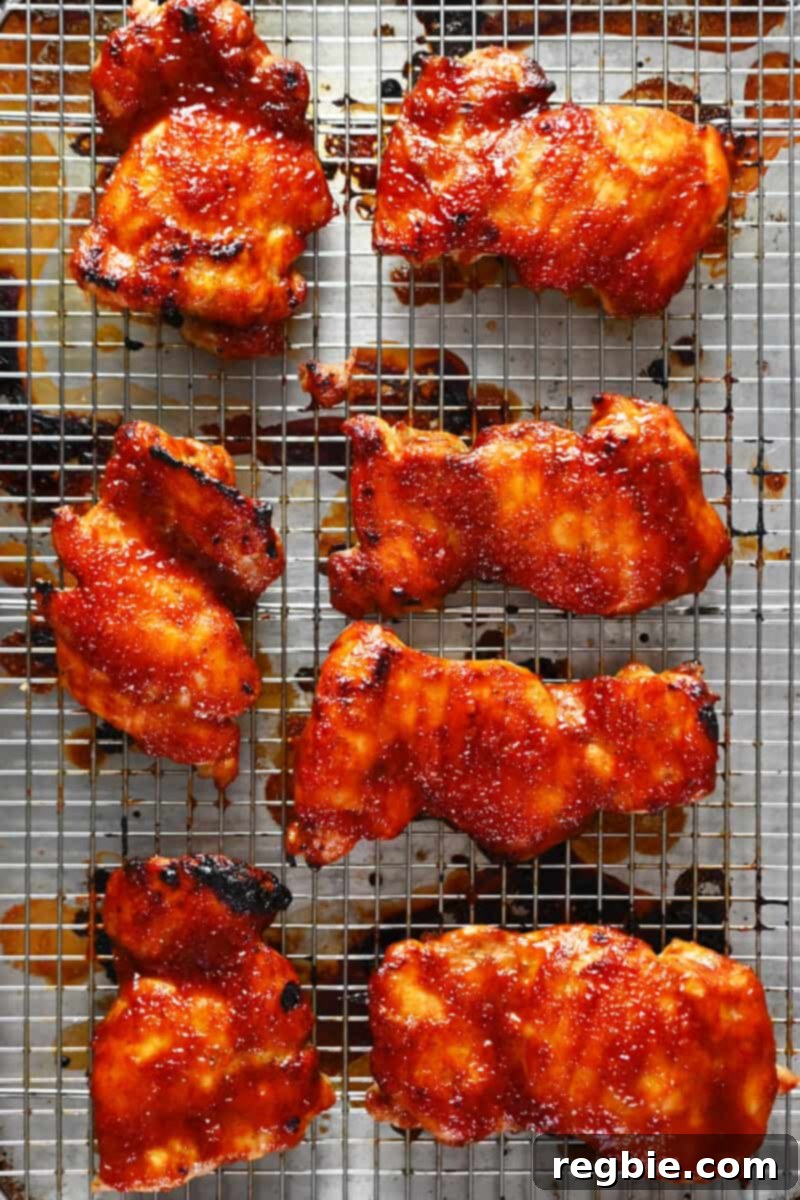 An overhead shot of a tray of perfectly cooked Char Siu chicken, fresh out of the oven, with a rich, caramelized sauce.