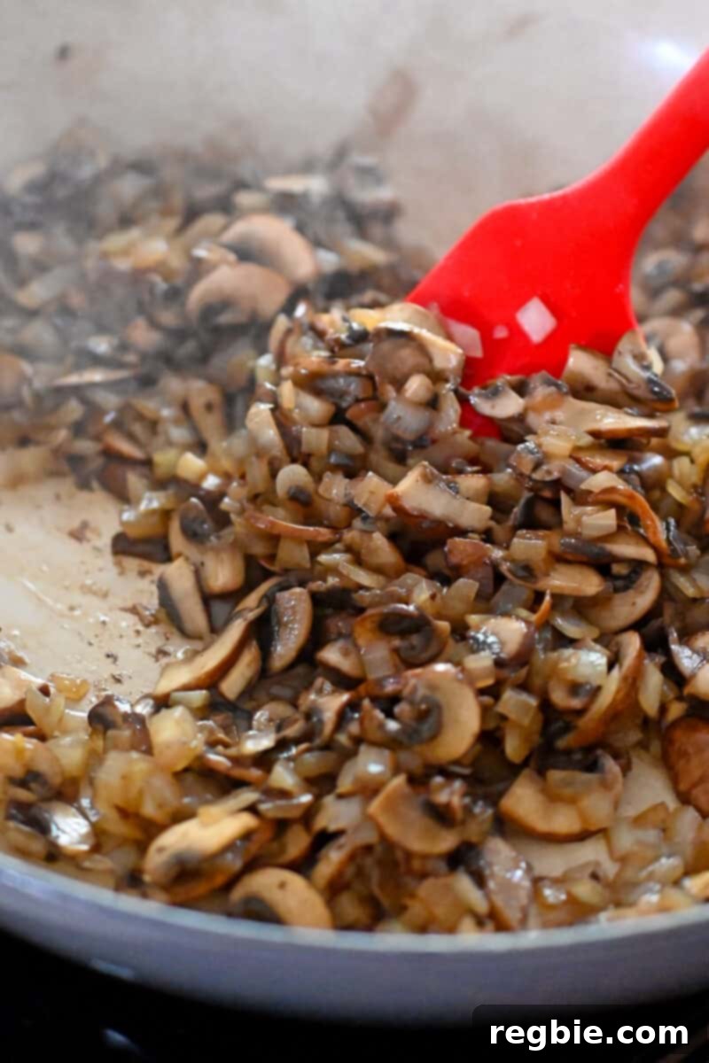 Sautéed sliced mushrooms and onions cooked in a skillet until all the moisture has evaporated, leaving them perfectly tender and caramelized.