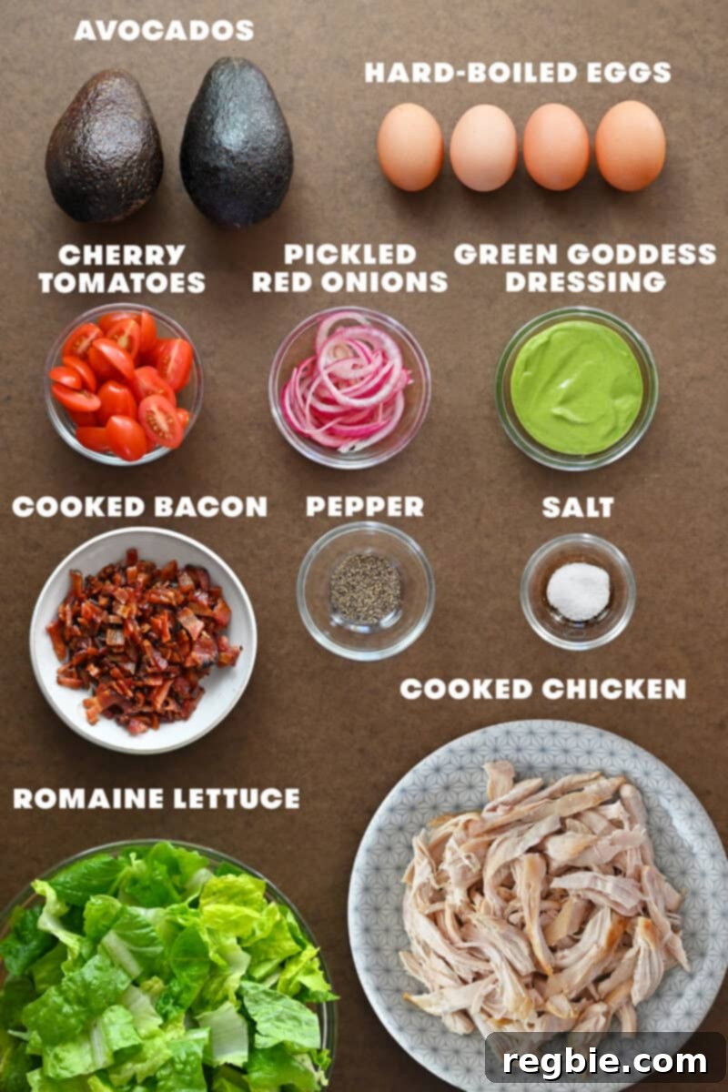 An overhead shot showcasing the fresh, raw ingredients laid out to make the homemade Green Goddess Cobb Salad, a healthy Panera copycat recipe.