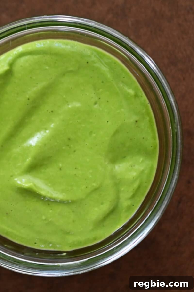 An overhead shot of a jar of homemade Whole30 and vegan Green Goddess Dressing, ready to be used for the salad.