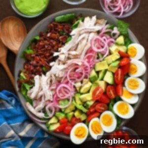 An overhead shot of a paleo and Whole30 Green Goddess Cobb Salad Panera copycat, featuring colorful ingredients beautifully arranged.