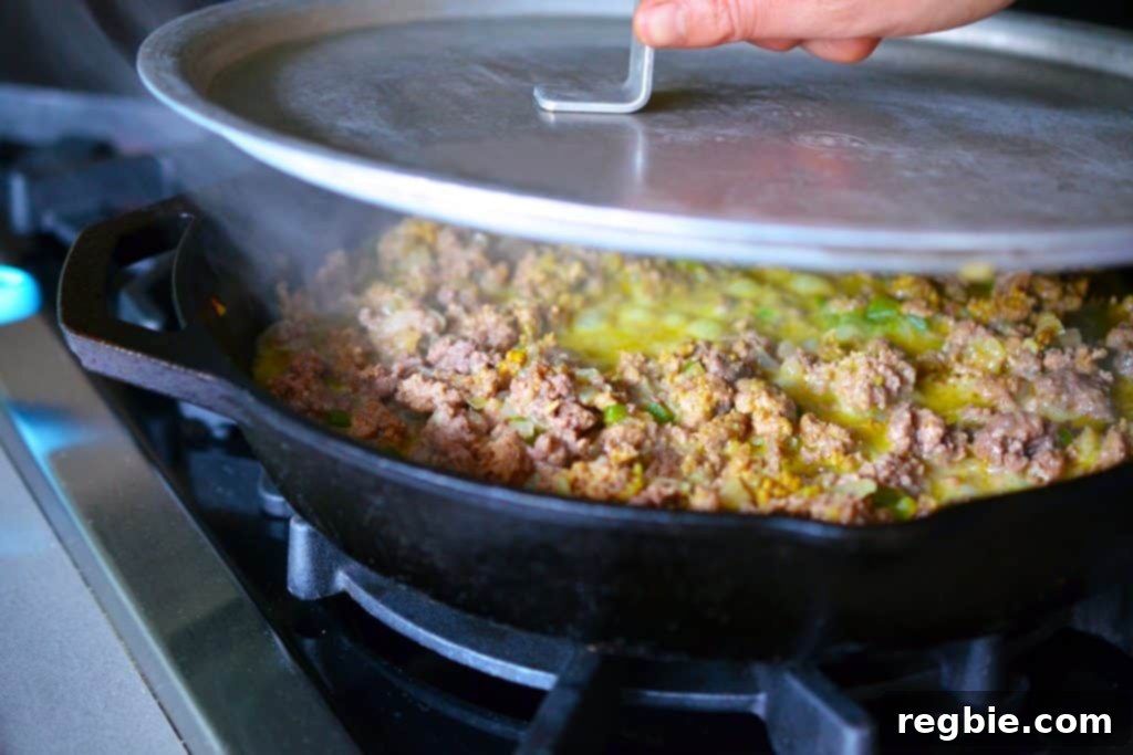Aromatic Keema Samosa Platter 12 A pan with spiced keema mixture being covered with a lid to simmer.