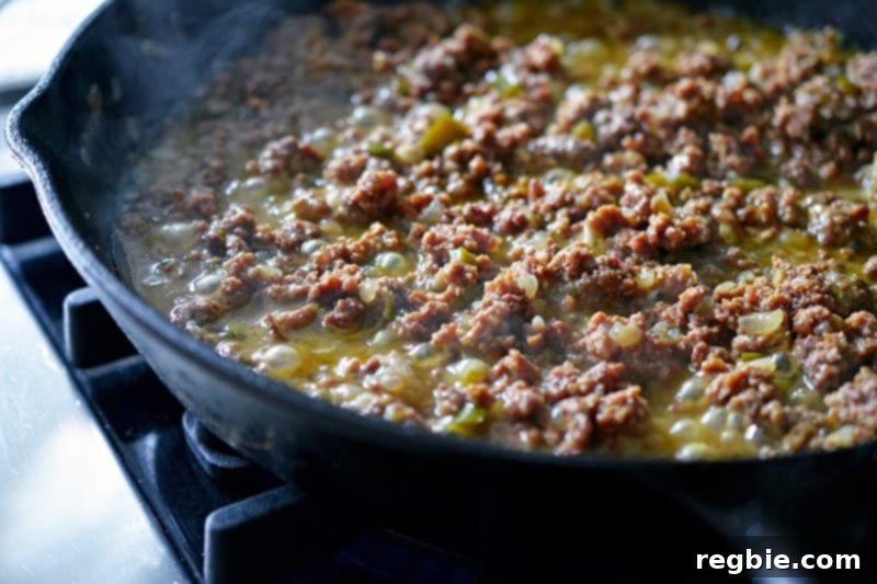 Aromatic Keema Samosa Platter 13 The spiced keema simmering in a pan, with liquid evaporating, resulting in a perfectly dry-cooked texture.