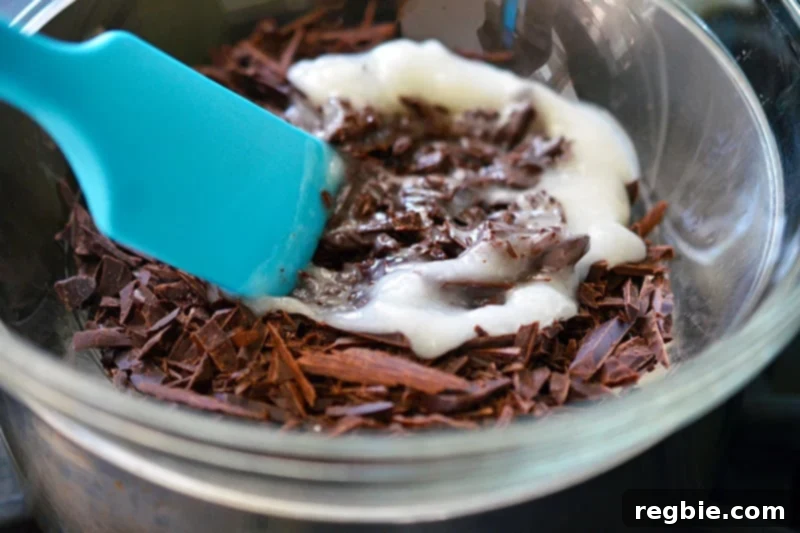 Guilt-Free Chunky Monkey Nice Cream Bonbons 11 Generous slices of rich dark chocolate and a dollop of creamy coconut oil are being gently mixed together in a clear glass bowl, beginning their transformation into a luscious coating.