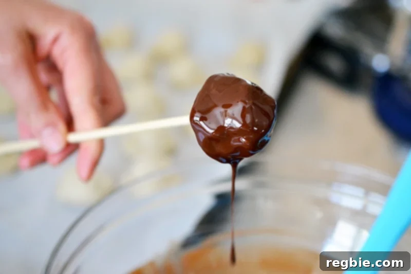Guilt-Free Chunky Monkey Nice Cream Bonbons 14 A perfectly formed banana nice cream scoop, now beautifully enveloped in a lustrous coat of melted dark chocolate, showcasing the magical transformation of this healthy dessert.