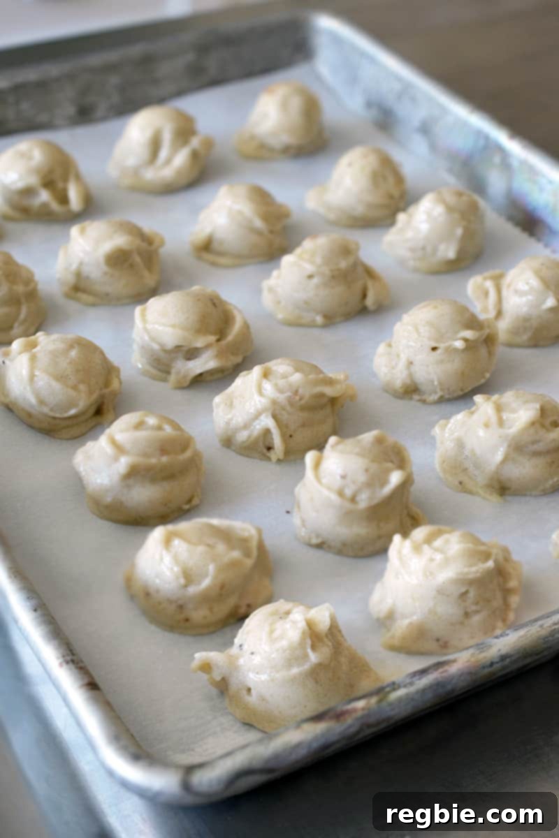 Guilt-Free Chunky Monkey Nice Cream Bonbons 10 A pristine side shot of a rimmed baking sheet showcasing rows of dairy-free banana nice cream scoops, diligently freezing to a solid state.