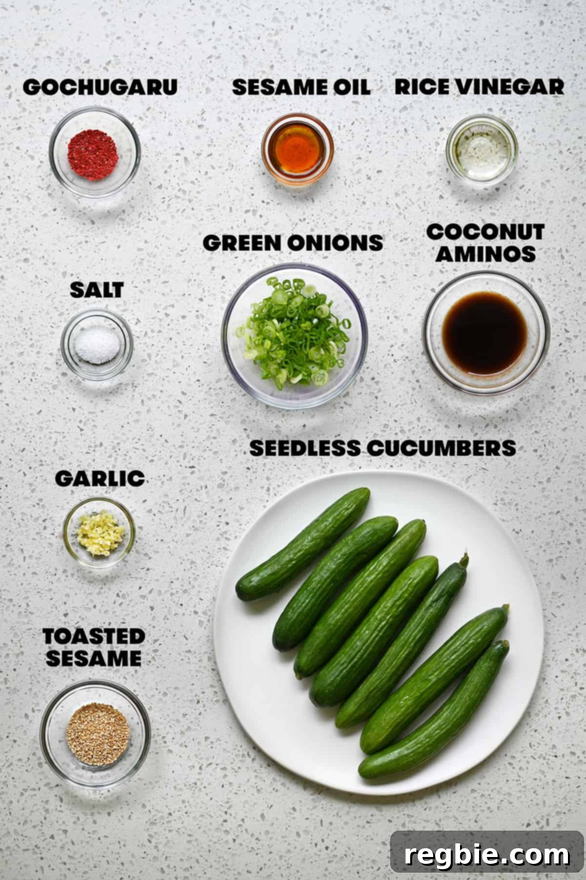A delightful arrangement of fresh, raw ingredients laid out on a clean surface, ready to be transformed into a paleo and gluten-free Korean cucumber salad.