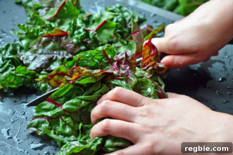 Another perspective of freshly chopped Swiss chard leaves on a wooden surface, highlighting their vibrant color and texture.